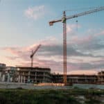 Construction site at sunset with two cranes